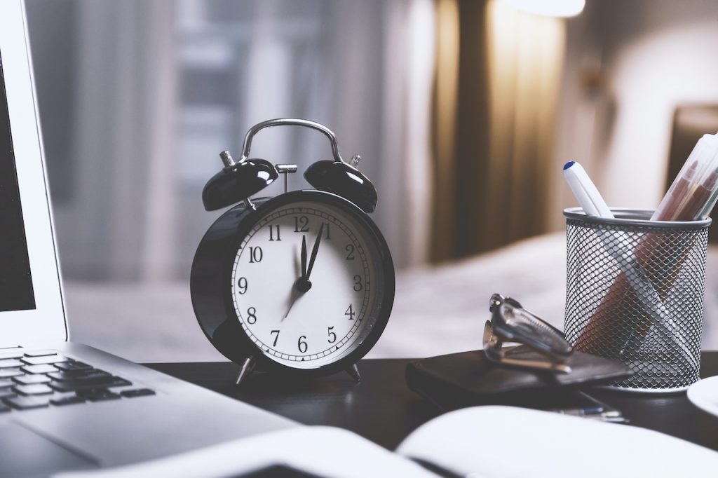 Black clock on a desk